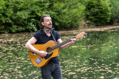 Johnethen Fuchs mit Gitarre am Wasser